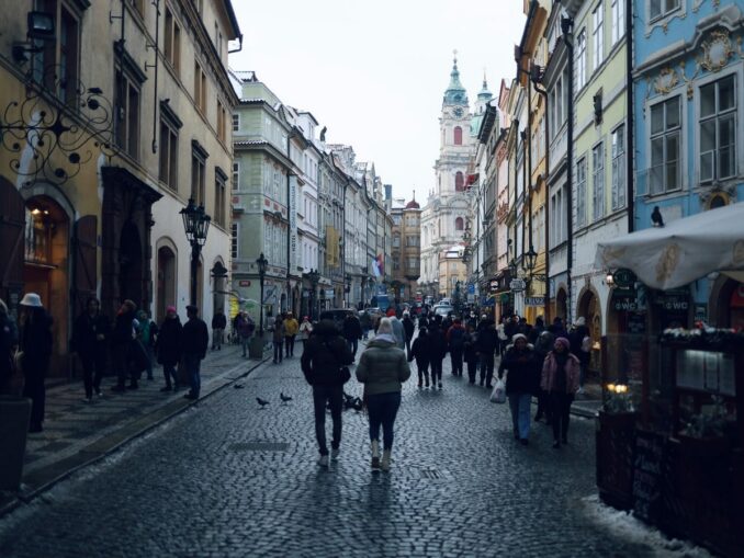 Prague street in winter, photo unsplash.com/@Αγγελος Αγοραστος In winter in Prague you need to dress very warmly: down jackets and short fur coats